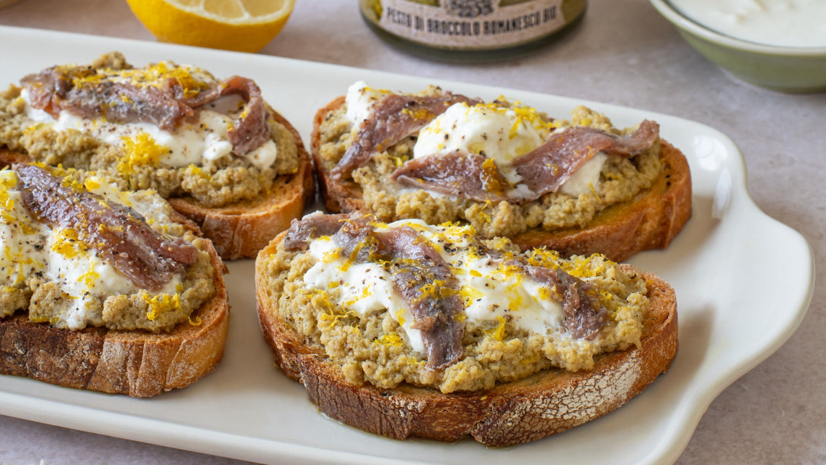 Bruschette con crema di broccolo romanesco Bio Orto, stracciatella, acciughe e scorza di limone