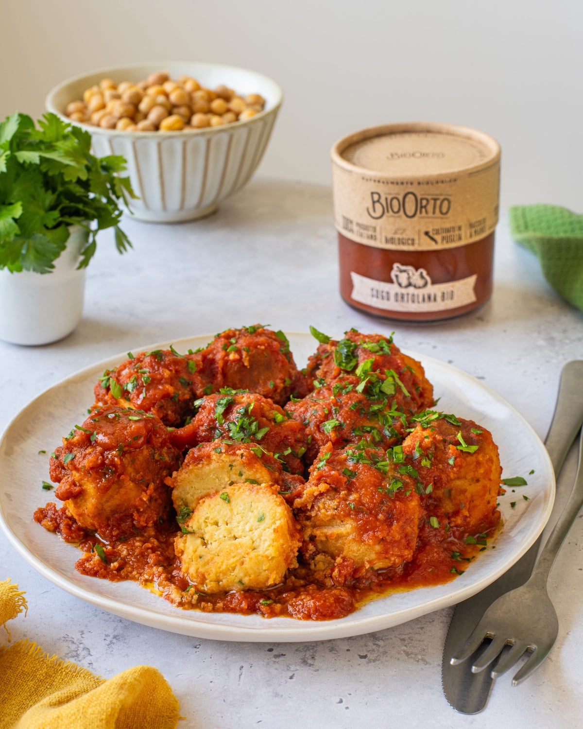 Polpette di ceci con sugo all'ortolana Bio Orto, con ceci e prezzemolo accanto al piatto